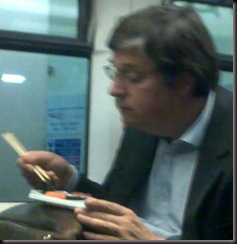 man eating sushi on train