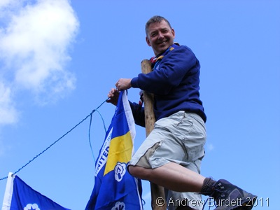 MAN UP_Jim Payen hanging a Jamboree UK Contingent flag on the gateway.
