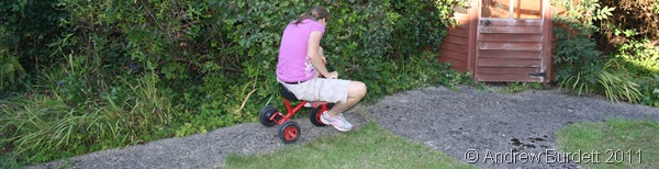 ONE LAST RIDE_Harriet taking the trike down to the end of the garden.