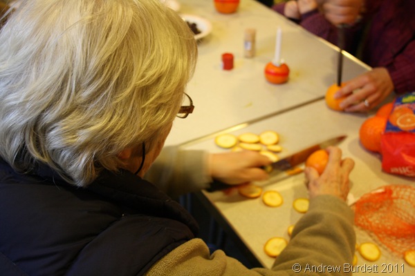 CUT ITS BOTTOM OFF_Ann Darracott assists with the flattening of the bottoms of the oranges.