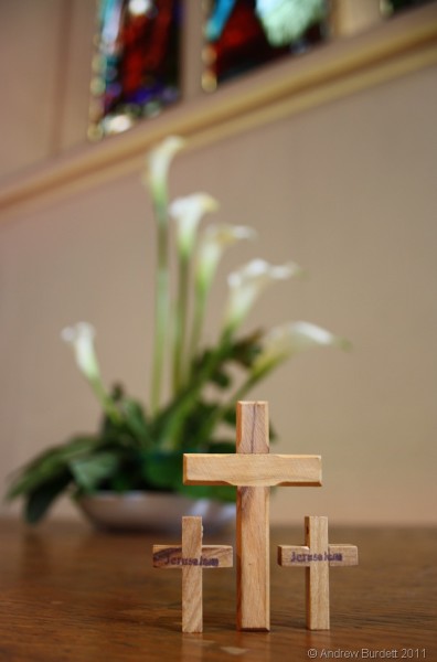 Easter lilies and three crosses sit on the bare altar at St Luke's Church, Maidenhead.