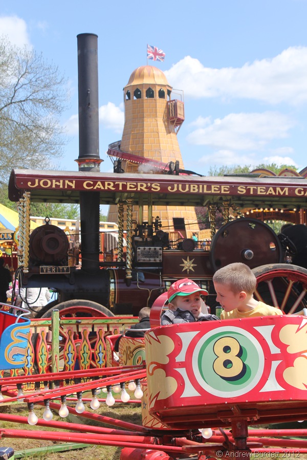 MILDLY TERRIFIED: Children enjoy one of the younger rides in front of the Verity steam engine and helter-skelter. (IMG_2665)