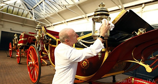 RIGHT ROYAL RUBDOWN: A man prepares the Royal Carriage ahead of Tuesday's procession. (_60557755_014881433-2)