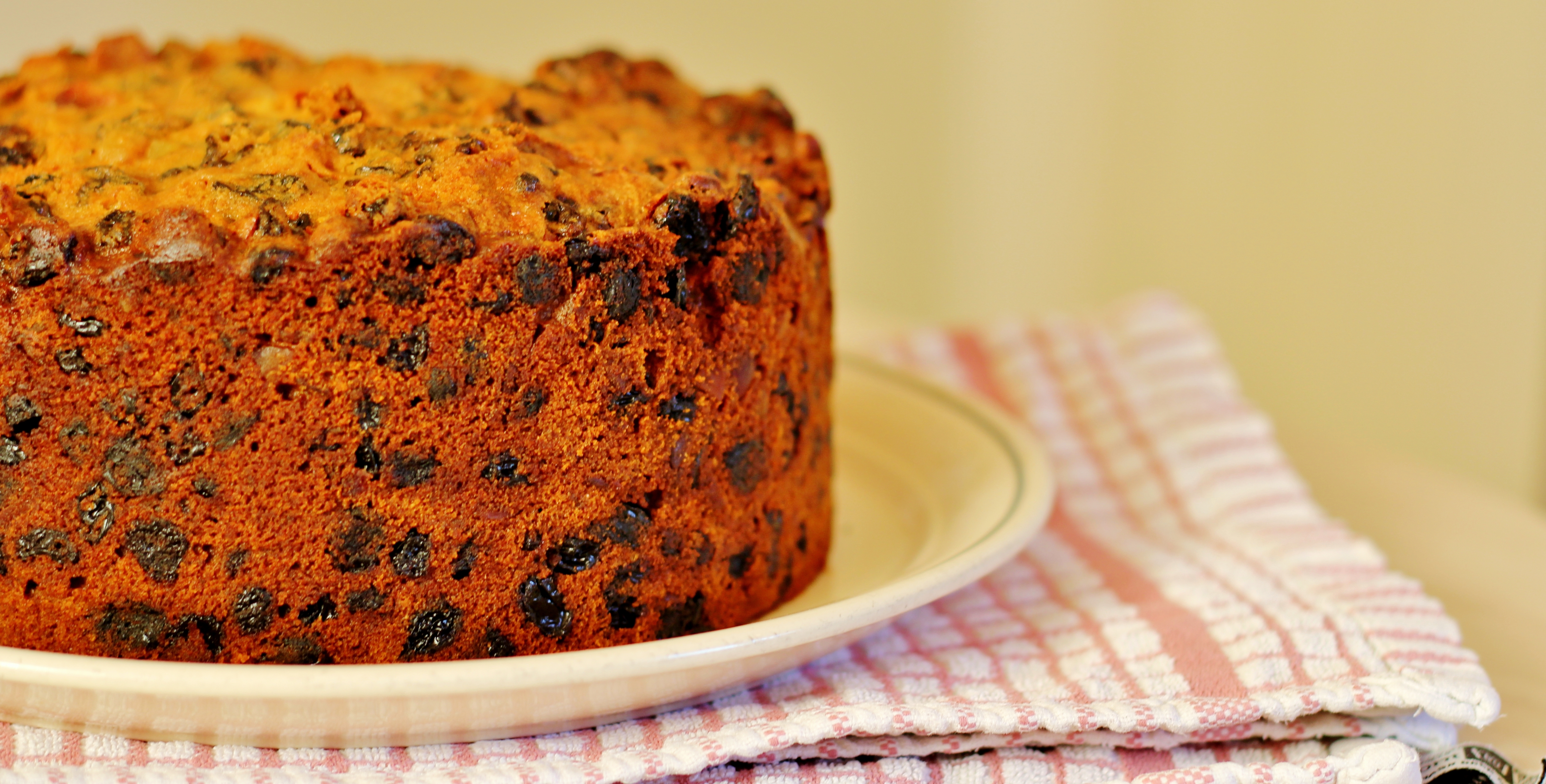A Christmas cake sits on a plate, ready to be iced.
