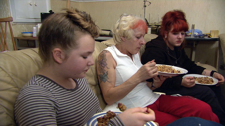 A widow and her two daughters eat a meal Rachel Johnson has prepared.