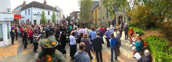 A panorama showing the Good Friday Walk of Witness attendees assembled around the Boy And Boat statue, at the top of Maidenhead High Street.