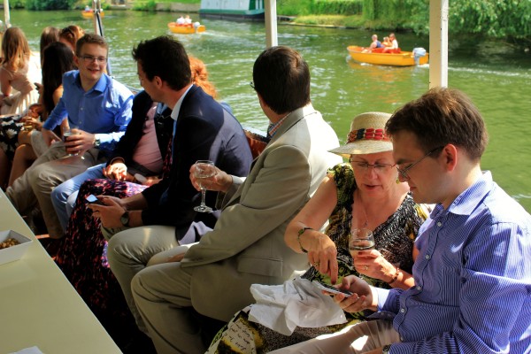 Guests enjoying the pleasant weather from the shelter of the party boat's canopy.