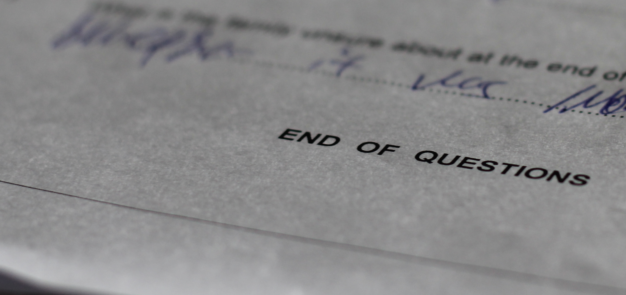 An exams paper with the words "End of Questions" visible.