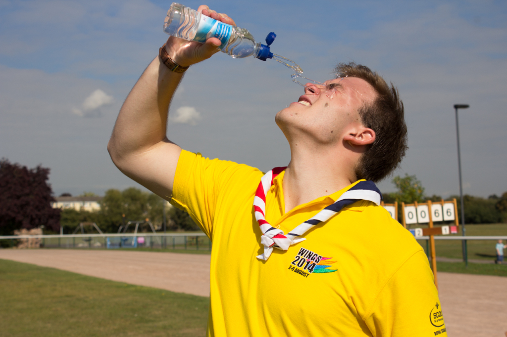 Andrew Burdett squirting a water-bottle over his face, to cool himself down.