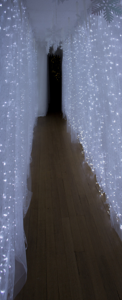 Leading from one part of the house to another, a corridor is decorated with a star-curtain.