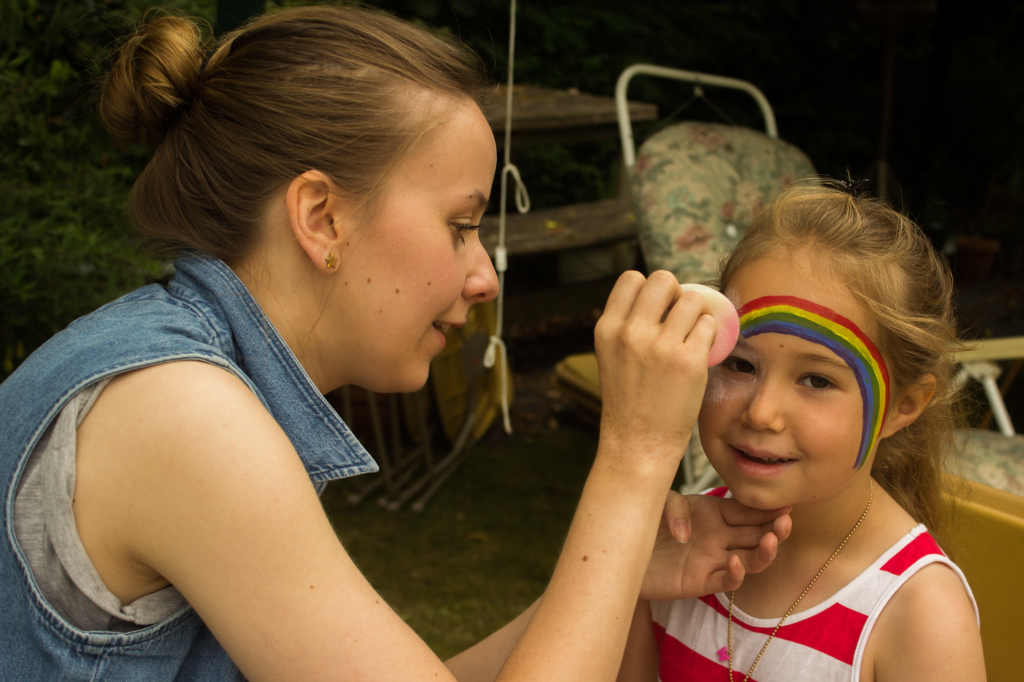 Ruth Baughan paints a rainbow on Charlotte's face.