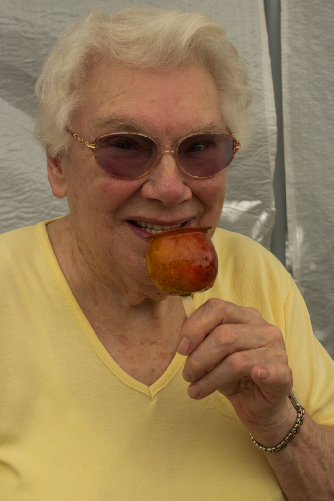 Phyllis Sigsworth takes a bite out of a toffee apple.