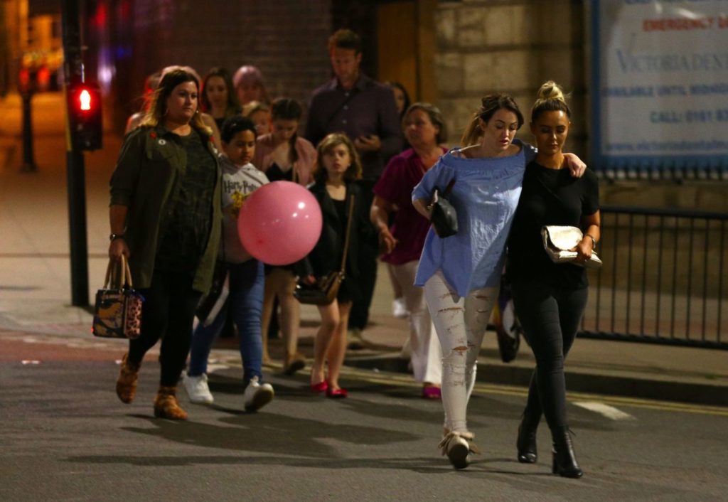 Concert-goers walk away from the Manchester Arena following a bombing there.