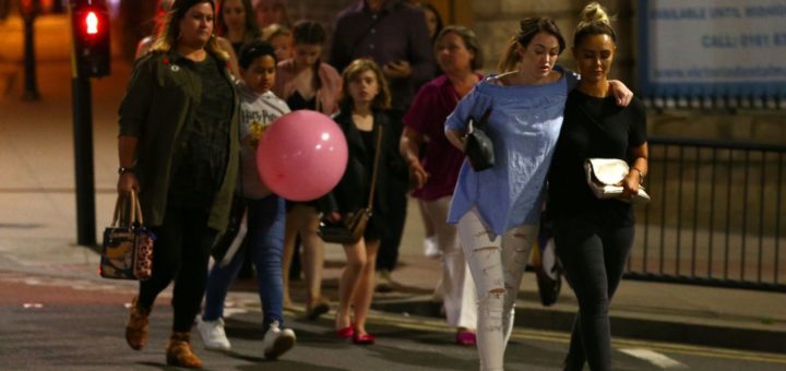 Concert-goers walk away from the Manchester Arena following a bombing there.
